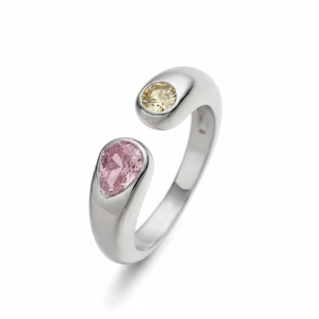 Anillo abierto Ámbar Joyas en tono plateado con dos circonitas en forma de gota, una rosa y otra amarilla.