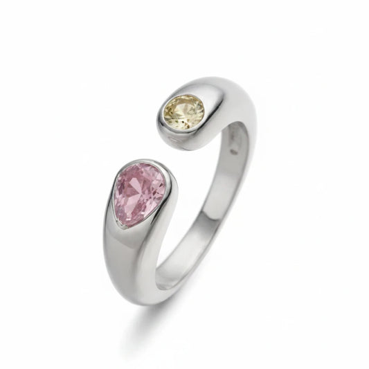Anillo abierto Ámbar Joyas en tono plateado con dos circonitas en forma de gota, una rosa y otra amarilla.