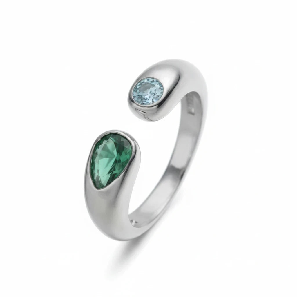 Anillo abierto Ámbar Joyas de tono plateado con dos circonitas en forma de gota, una verde y una azul claro.
