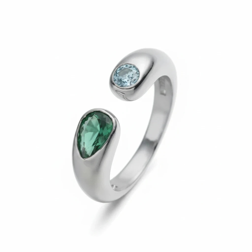 Anillo abierto Ámbar Joyas de tono plateado con dos circonitas en forma de gota, una verde y una azul claro.