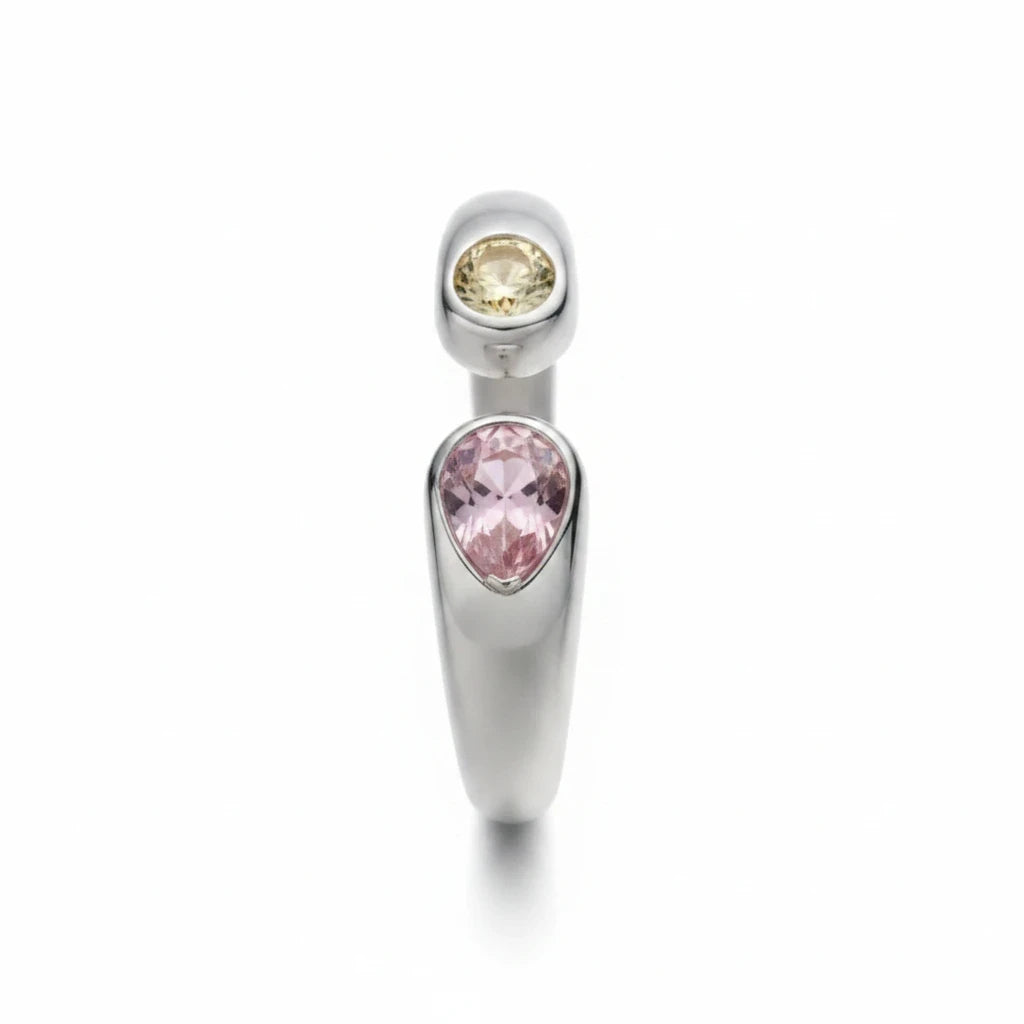 Anillo abierto Ámbar Joyas en tono plateado con dos circonitas en forma de gota, una rosa y una amarilla.
