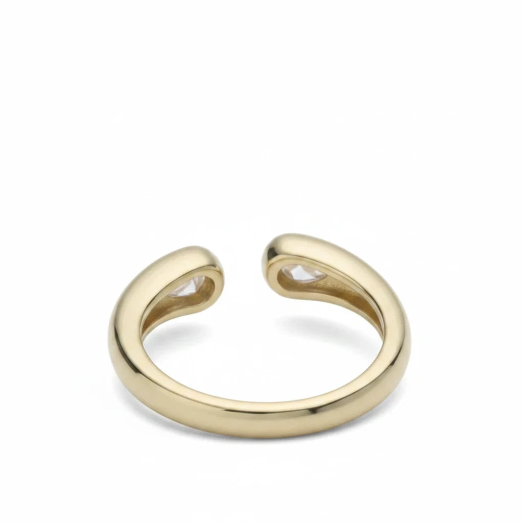 Anillo abierto Ámbar Joyas en tono dorado con dos circonitas blancas en forma de gota en los extremos.