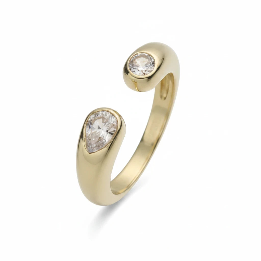 Anillo abierto Ámbar Joyas en tono dorado con dos circonitas blancas en forma de gota y banda pulida.