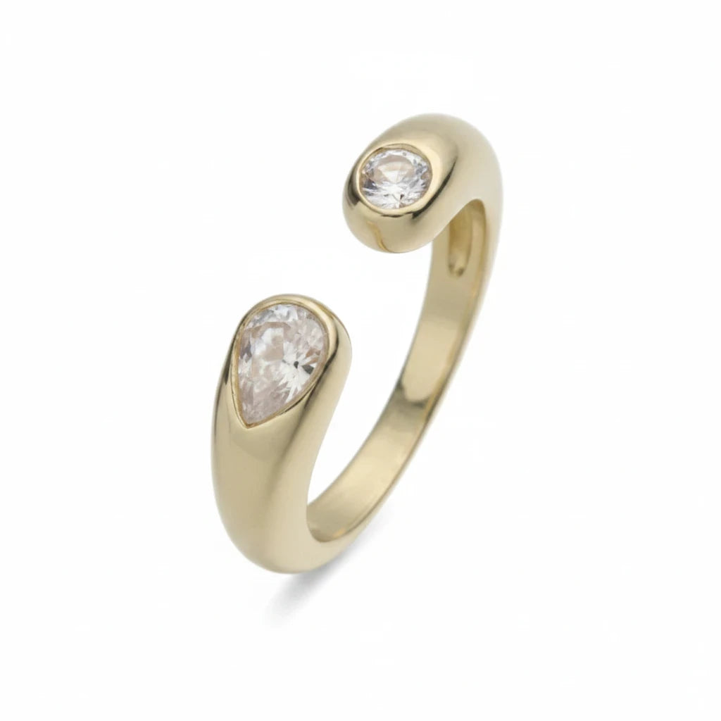Anillo abierto Ámbar Joyas en tono dorado con dos circonitas blancas en forma de gota en los extremos.