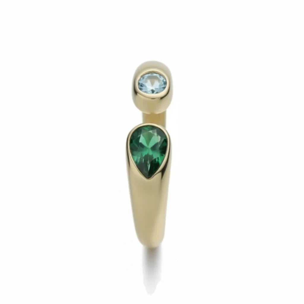 Anillo abierto Ámbar Joyas en metal dorado con circonita azul redonda y piedra verde en forma de lágrima.
