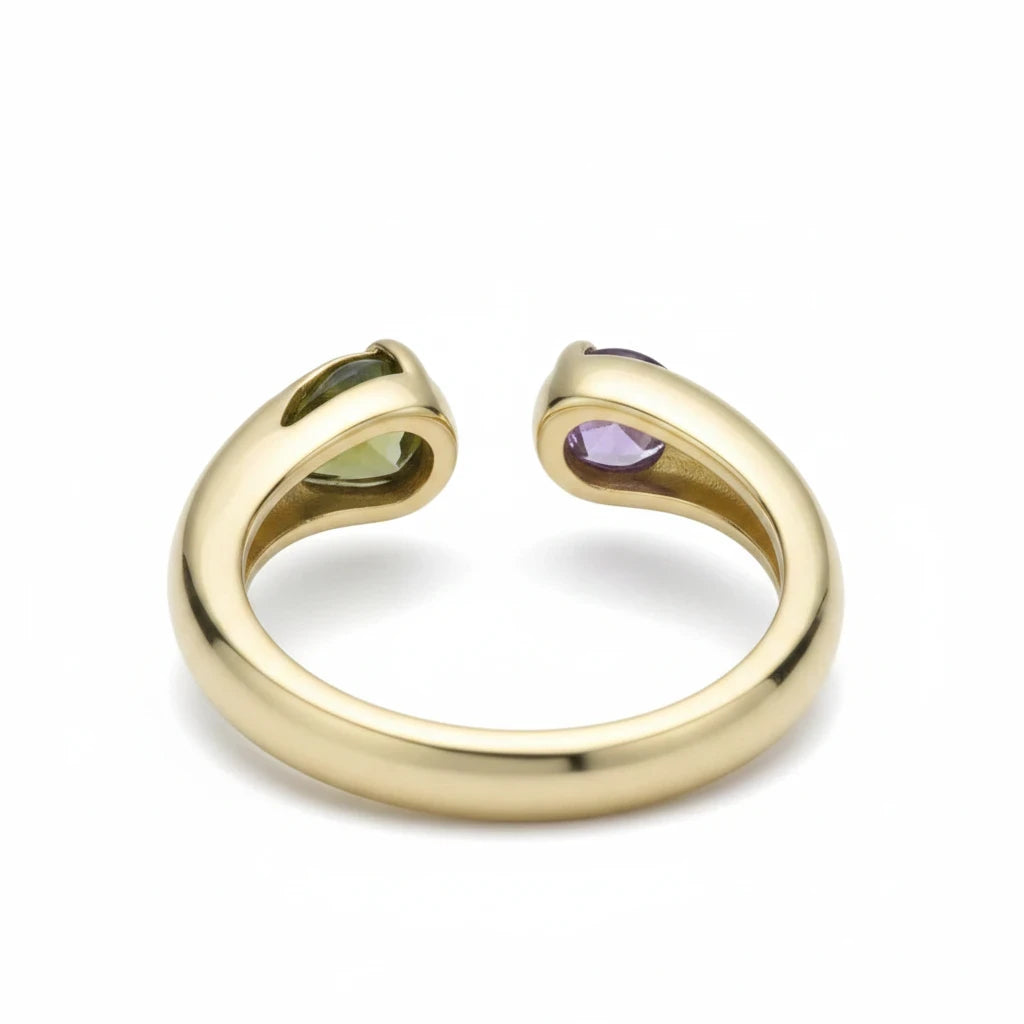 Anillo abierto Ámbar Joyas en tono dorado con una piedra verde en forma de gota y una piedra circular violeta.