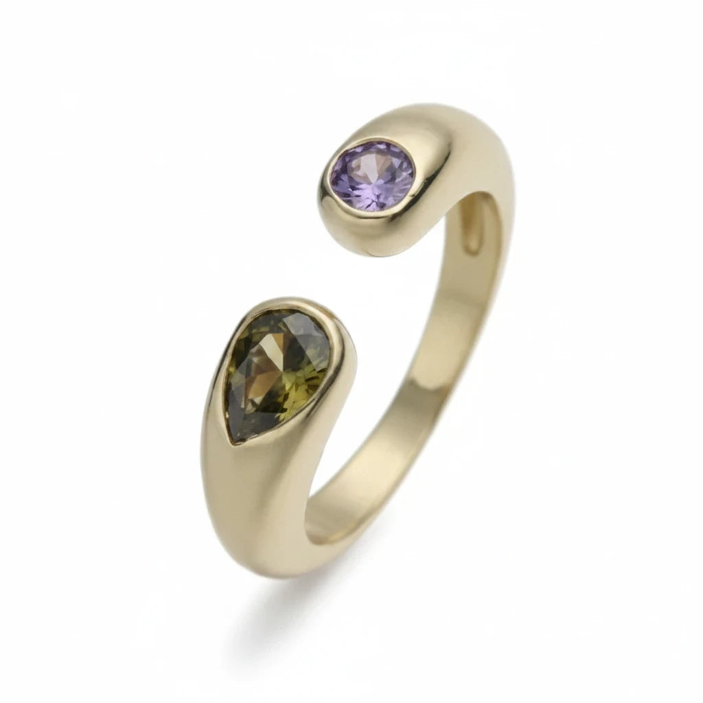 Anillo abierto Ámbar Joyas en tono dorado con piedra gota verde y piedra circular violeta, diseño contemporáneo.