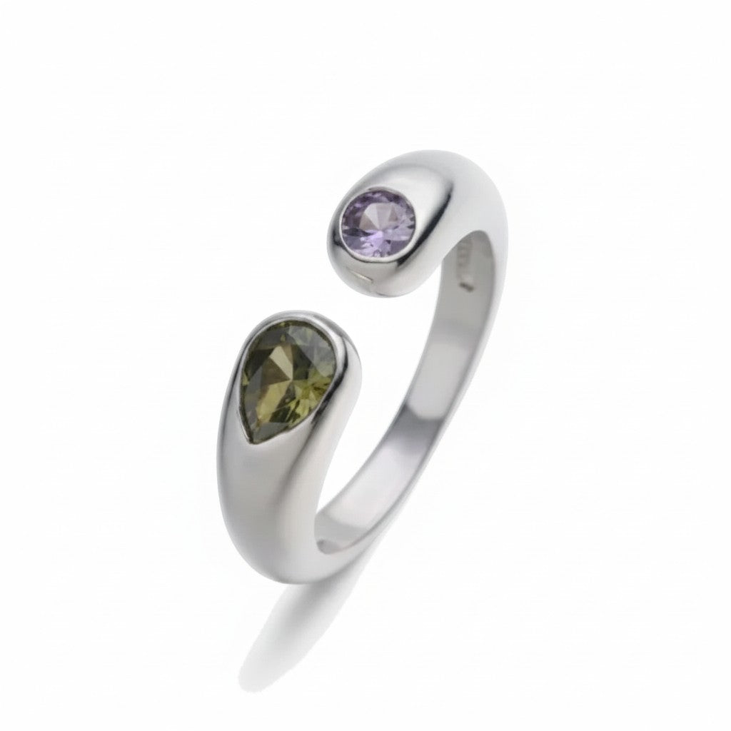 Anillo abierto Ámbar Joyas en tono plateado con dos circonitas en talla gota, una morada y otra oliva.