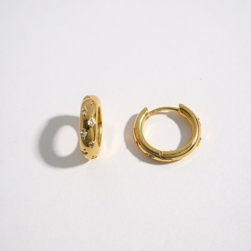Aros huggie Ámbar Joyas con baño de oro 18k y circones incrustados, diseño minimalista y elegante.
