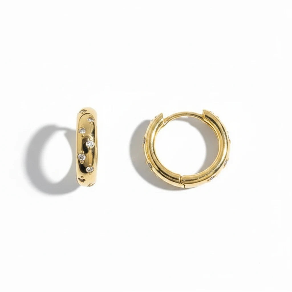 Aros huggie Ámbar Joyas con baño de oro 18k y pequeños circones brillantes, diseño minimalista y elegante.